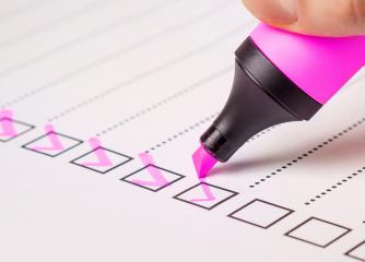En lila penna kryssar i en ruta på en checklista