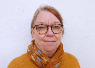 Kvinna med glasögon och kort blont hår