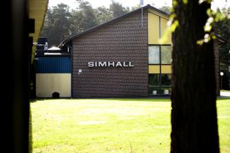 En tegelbyggnad med texten Simhall