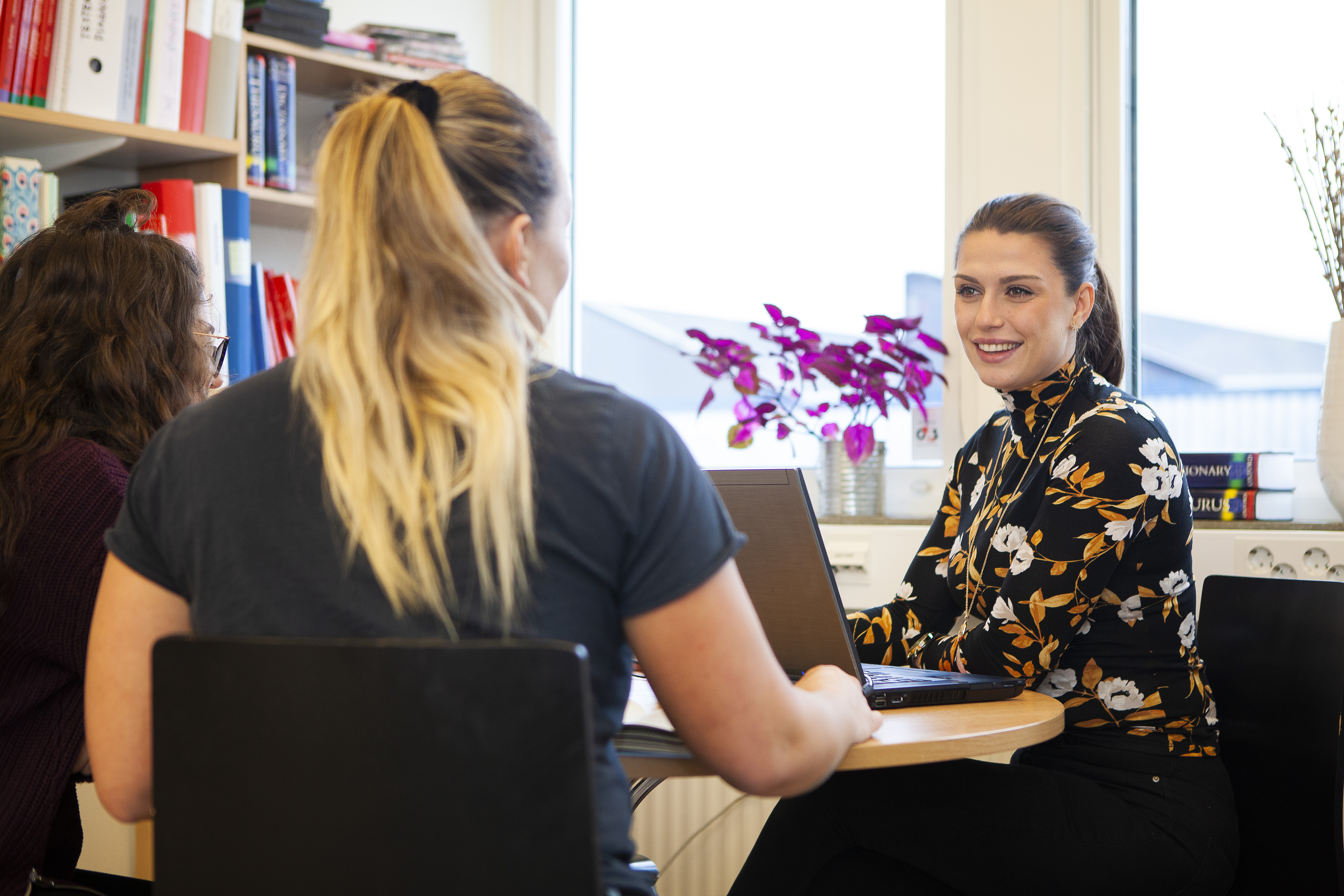 En person i samtal med två andra
