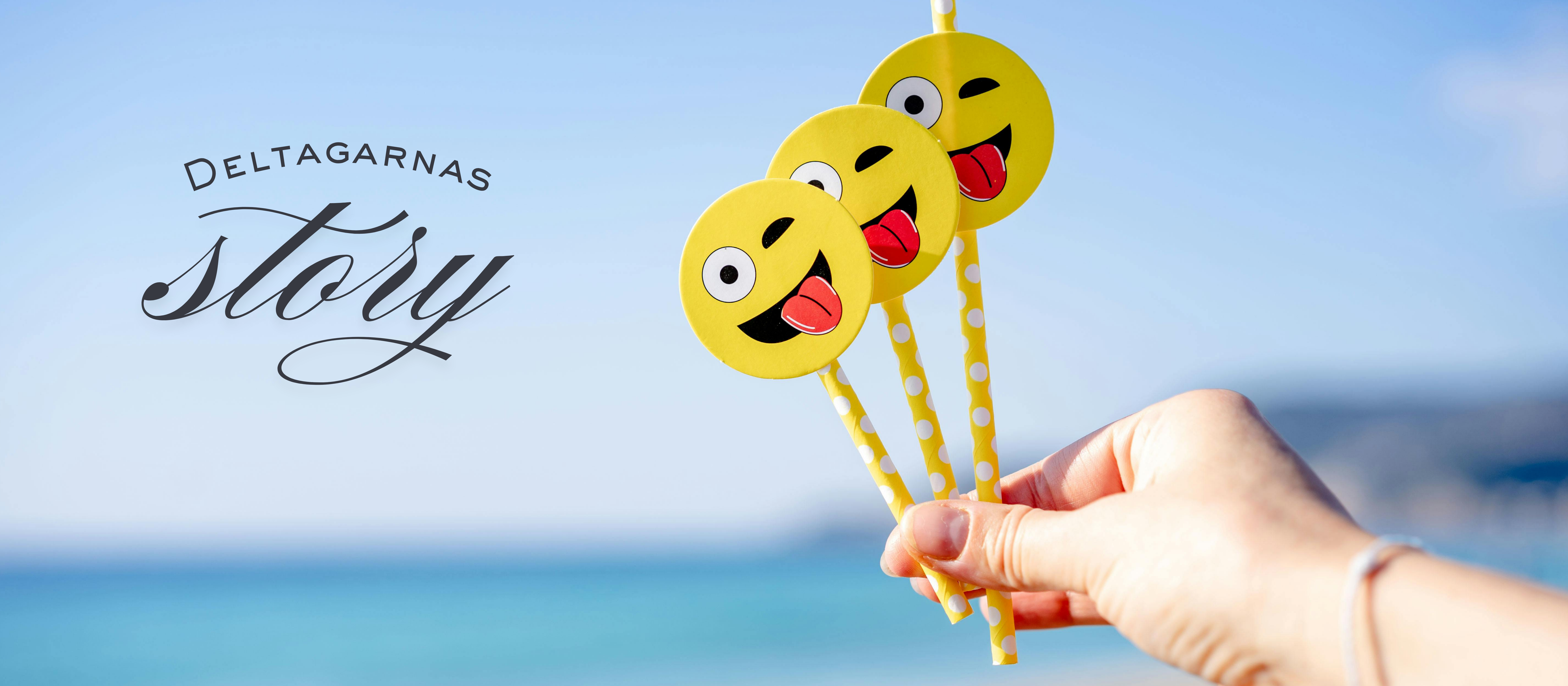 En hand håller i tre olika smileys