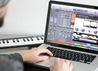 Person sitter vid en dators mixerbord