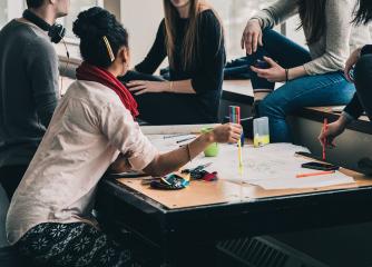 En grupp deltagare sitter runt ett bord