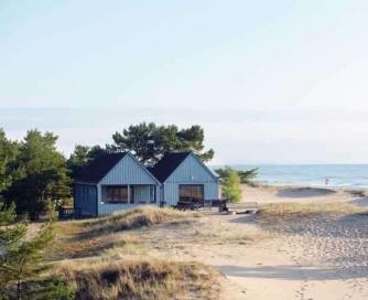 Strandstugan - En blå byggnad vid en strand nära havet