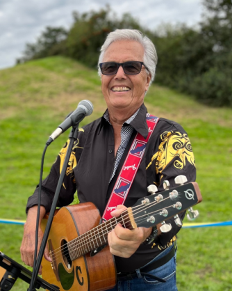 glad man med gitarr, han är utomhus